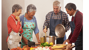 A picture of two old ladies and two old men cooking food